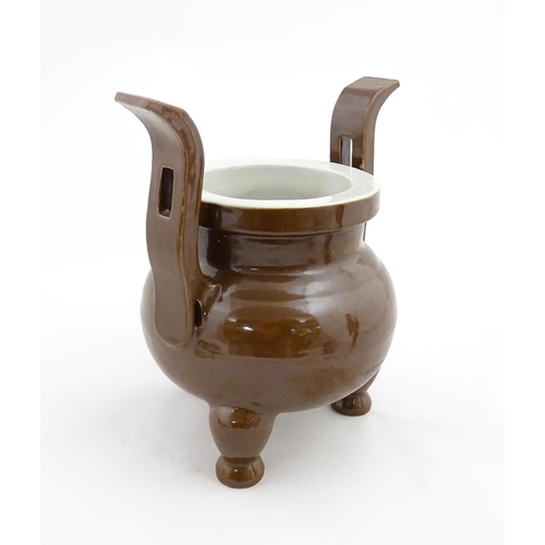 51 - A large Chinese censer with brown ground and twin upright handles. Impressed Character marks to rim.... 