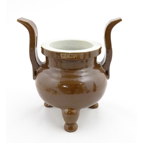 51 - A large Chinese censer with brown ground and twin upright handles. Impressed Character marks to rim.... 