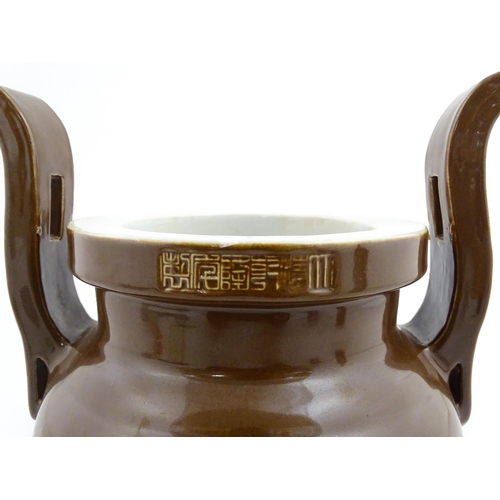 51 - A large Chinese censer with brown ground and twin upright handles. Impressed Character marks to rim.... 