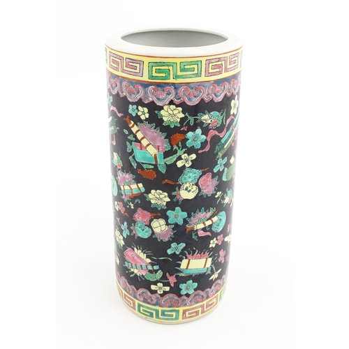 9 - A Chinese famille rose vase of cylindrical form decorated with auspicious symbols on a black ground.... 