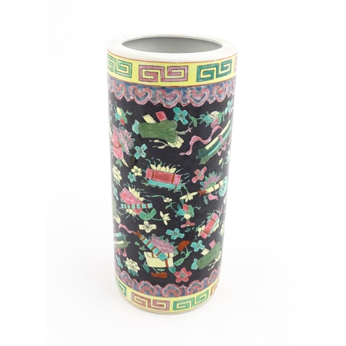 9 - A Chinese famille rose vase of cylindrical form decorated with auspicious symbols on a black ground.... 