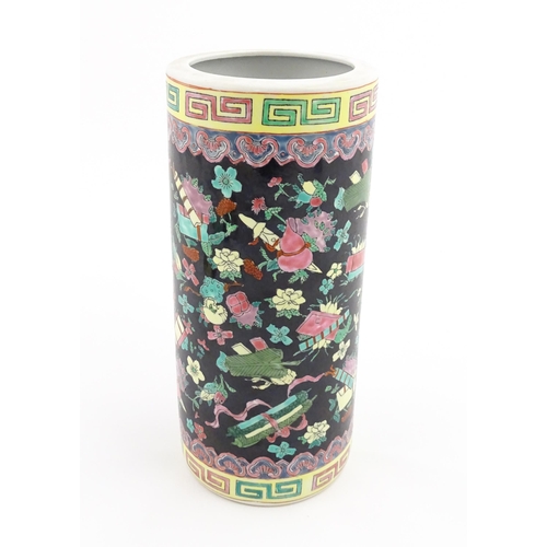 9 - A Chinese famille rose vase of cylindrical form decorated with auspicious symbols on a black ground.... 