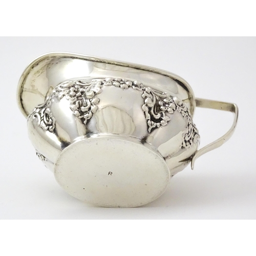 346 - A silver cream jug with embossed decoration hallmarked Birmingham 1901, maker William Aitken. Approx... 