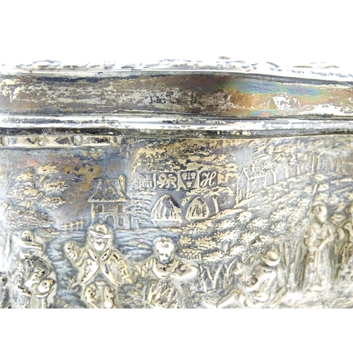 374 - An early 20thC silver jewellery box with embossed decoration depicting figures in landscape with hou... 