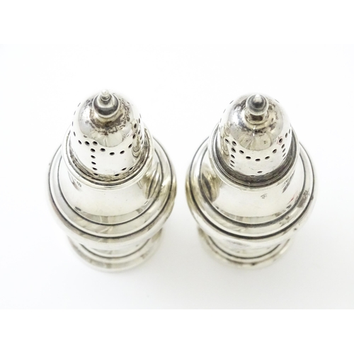 376 - A pair of silver pepperettes hallmarked Birmingham 1912, maker William Hutton & Sons Ltd. Approx. 4