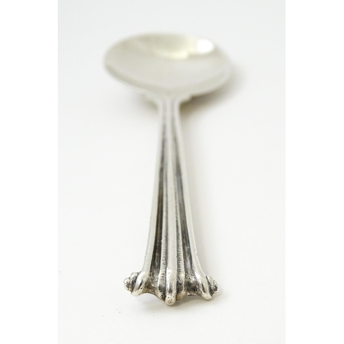 389 - Leslie G Durbin: A modern silver spoon with reeded handle and scroll finial, rat tail, and hammered ... 