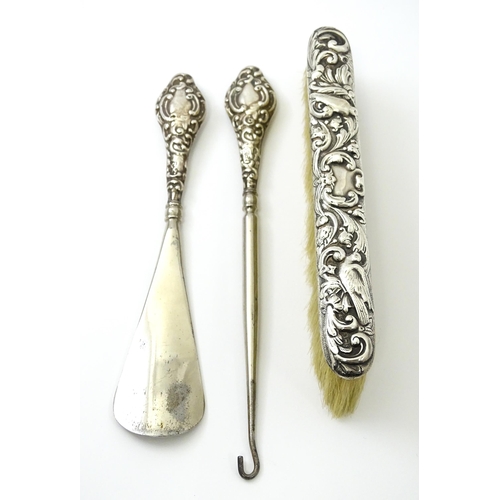 461 - A silver button hook and shoe horn, hallmarked Chester 1910. Together with a silver mounted brush ha... 