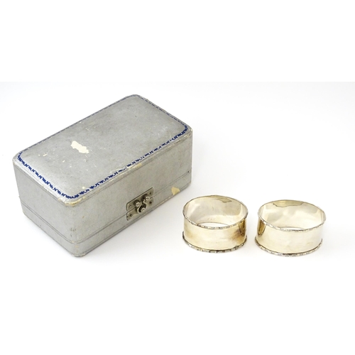 462 - A cased pair of silver napkin rings of oval form, hallmarked Birmingham 1938 maker Adie Brothers Ltd... 