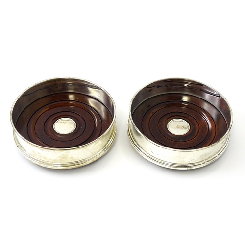 465 - A pair of silver bottle coasters with turned wooden bases, hallmarked Sheffield 2000, maker Carrs of... 