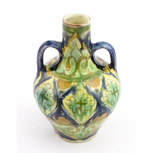 122A - A small Moorish vase with twin handles and banded decoration. In the manner of Della Robbia. Marked ... 