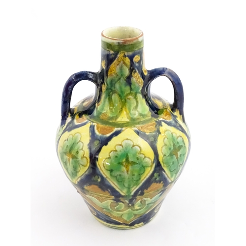 122A - A small Moorish vase with twin handles and banded decoration. In the manner of Della Robbia. Marked ... 