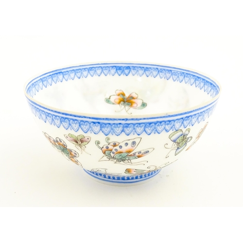 48 - Four Chinese items to include a tea bowl decorated with butterflies, a saucer with hand painted flor... 