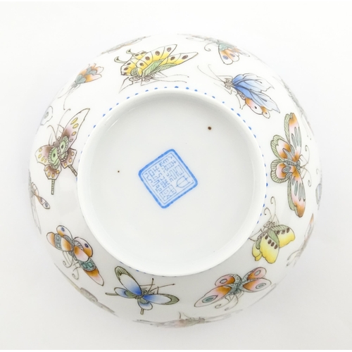 48 - Four Chinese items to include a tea bowl decorated with butterflies, a saucer with hand painted flor... 