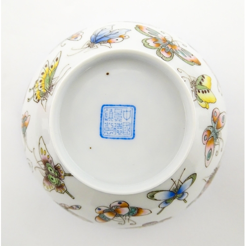 48 - Four Chinese items to include a tea bowl decorated with butterflies, a saucer with hand painted flor... 