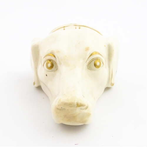 53 - A 19thC creamware stirrup cup of dog / hound head form with gilt detail. Approx. 4 3/4