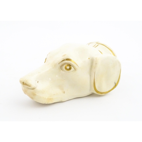 53 - A 19thC creamware stirrup cup of dog / hound head form with gilt detail. Approx. 4 3/4