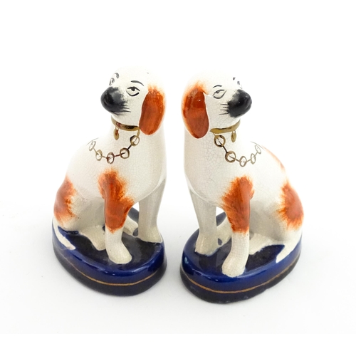 60 - A pair of Staffordshire pottery seated dogs with gilt collar and chain detail. Approx. 4 3/4