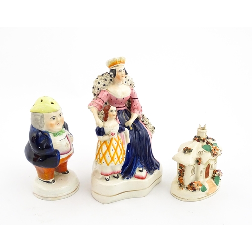 61 - Three items of Staffordshire pottery to include a figural Toby pepper pot, Queen Victorian and daugh... 