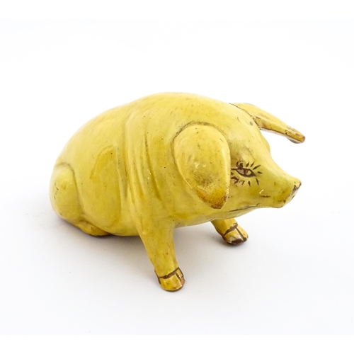 96 - A Welsh Ewenny pottery model of a seated pig with a yellow glaze. Signed under E. Jenkins Ewenny. Ap... 