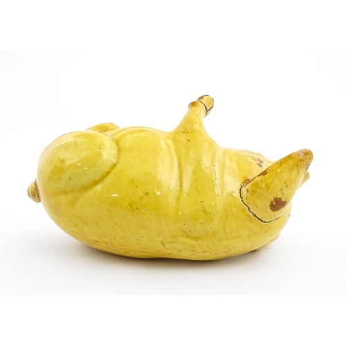 96 - A Welsh Ewenny pottery model of a seated pig with a yellow glaze. Signed under E. Jenkins Ewenny. Ap... 