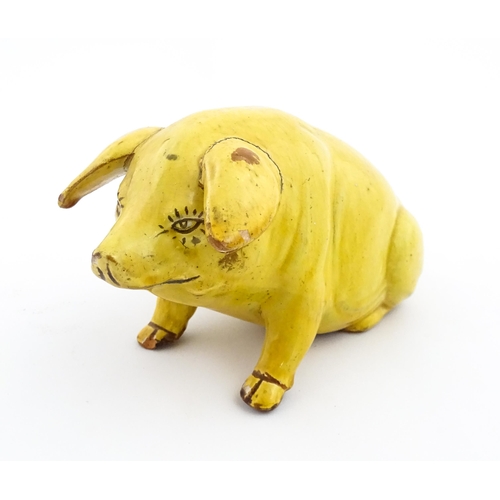 96 - A Welsh Ewenny pottery model of a seated pig with a yellow glaze. Signed under E. Jenkins Ewenny. Ap... 