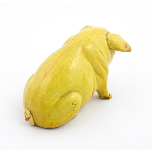 96 - A Welsh Ewenny pottery model of a seated pig with a yellow glaze. Signed under E. Jenkins Ewenny. Ap... 