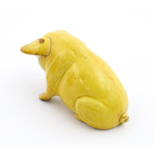 96 - A Welsh Ewenny pottery model of a seated pig with a yellow glaze. Signed under E. Jenkins Ewenny. Ap... 