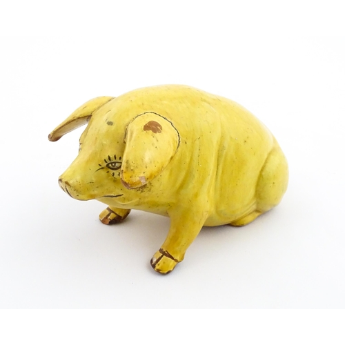 96 - A Welsh Ewenny pottery model of a seated pig with a yellow glaze. Signed under E. Jenkins Ewenny. Ap... 