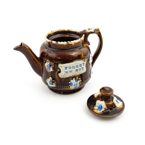 221 - A small Victorian Measham bargeware teapot bearing the motto Forget Me Not, with applied flower deta... 