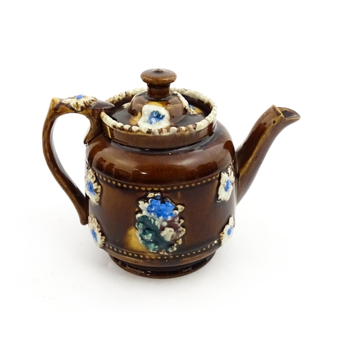 221 - A small Victorian Measham bargeware teapot bearing the motto Forget Me Not, with applied flower deta... 