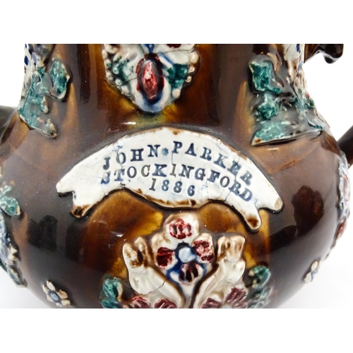 223 - A large Victorian Measham bargeware teapot bearing a plaque for John Parker Stockingford 1886, with ... 