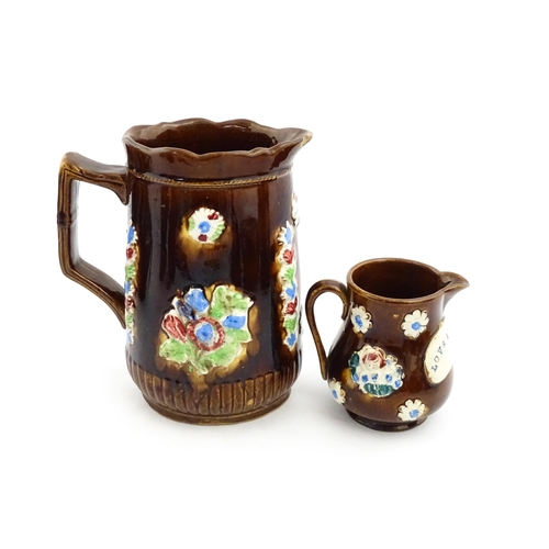 224 - Two Victorian Measham bargeware jugs bearing the motto Love At Home, both with applied flower detail... 