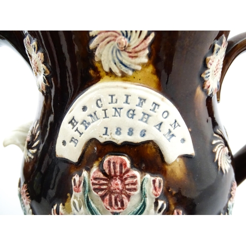 226 - A large Victorian Measham bargeware water jug bearing a plaque titled H Clifton Birmingham 1886, dec... 