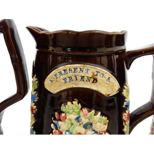 229 - A graduated set of three Victorian Measham bargeware jugs, each bearing a plaque titled A Present to... 