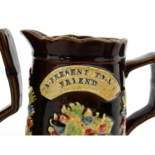 229 - A graduated set of three Victorian Measham bargeware jugs, each bearing a plaque titled A Present to... 