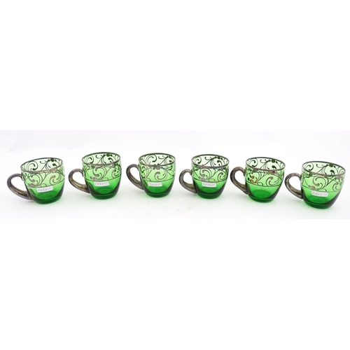 288 - A Spanish green glass punch bowl with ladle and six punch cups with silvered overlay detail. Marked ... 