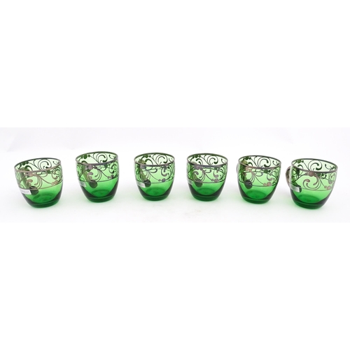 288 - A Spanish green glass punch bowl with ladle and six punch cups with silvered overlay detail. Marked ... 