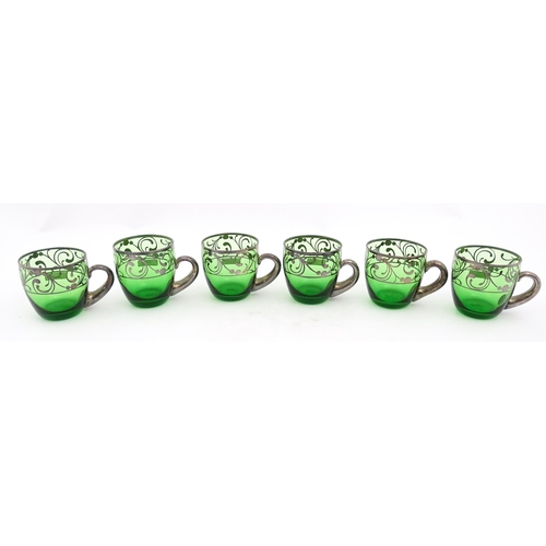 288 - A Spanish green glass punch bowl with ladle and six punch cups with silvered overlay detail. Marked ... 