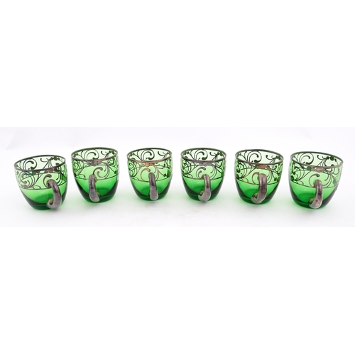 288 - A Spanish green glass punch bowl with ladle and six punch cups with silvered overlay detail. Marked ... 