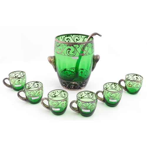 288 - A Spanish green glass punch bowl with ladle and six punch cups with silvered overlay detail. Marked ... 