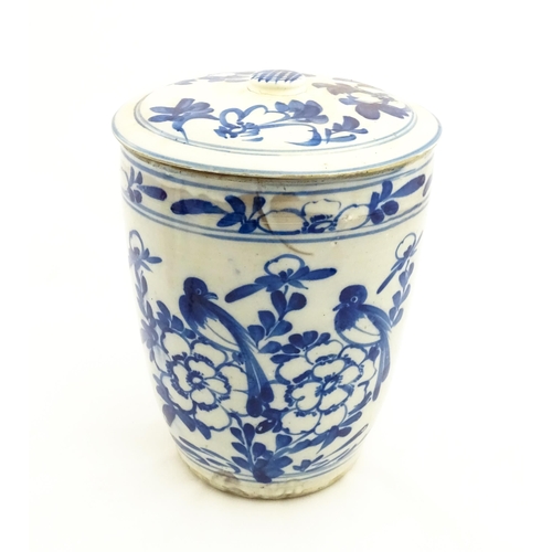 154 - A large earthenware blue and white lidded jar decorated with flowers and birds. Approx. 14 1/2