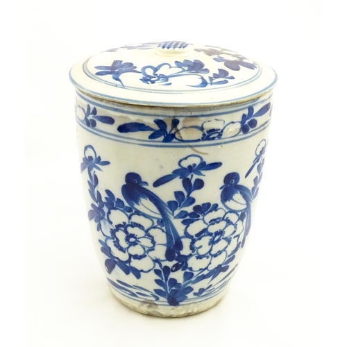 154 - A large earthenware blue and white lidded jar decorated with flowers and birds. Approx. 14 1/2