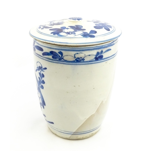 154 - A large earthenware blue and white lidded jar decorated with flowers and birds. Approx. 14 1/2