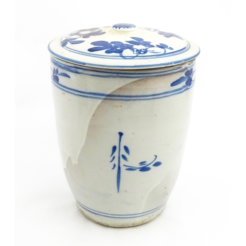 154 - A large earthenware blue and white lidded jar decorated with flowers and birds. Approx. 14 1/2