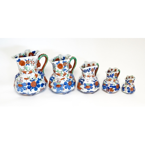 184 - A graduated set of five ironstone china jugs with floral and foliate decoration. Marked under. Large... 