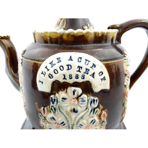 215 - A Victorian Measham bargeware teapot and stand, the teapot bearing the motto I Like a Good Cup of Te... 