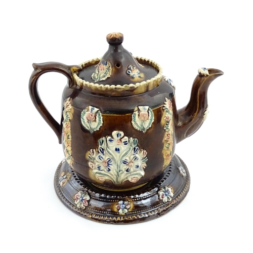 215 - A Victorian Measham bargeware teapot and stand, the teapot bearing the motto I Like a Good Cup of Te... 