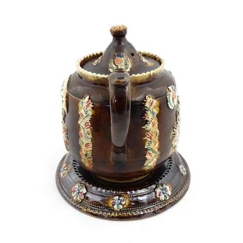 215 - A Victorian Measham bargeware teapot and stand, the teapot bearing the motto I Like a Good Cup of Te... 