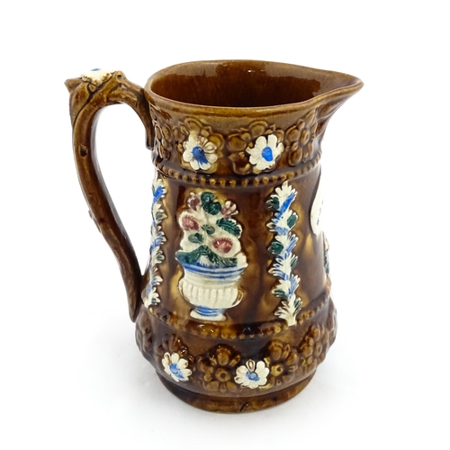 216 - A Victorian Measham bargeware jug with Forget Me Not motto, decorated with flowers, foliage and havi... 