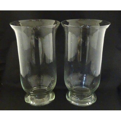 340 - A pair of clear glass storm lanterns with large candles, each approx 16